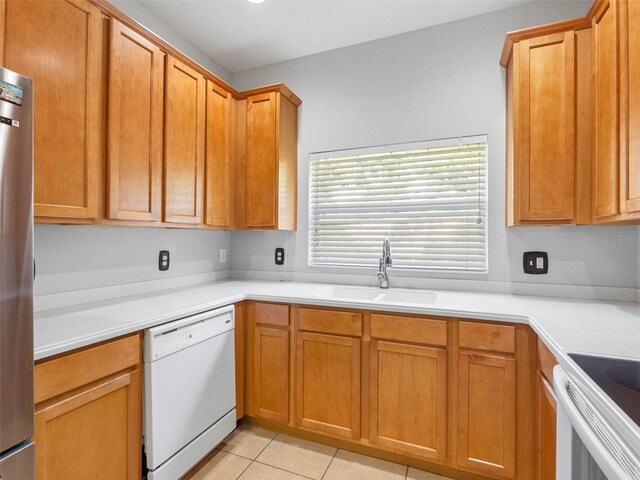 12820 Belvedere Song Way, Riverview, FL 33578 - kitchen featuring white appliances, light tile patterned flooring, light countertops, and brown cabinetry
