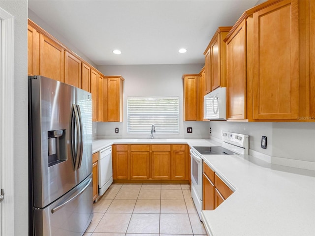 12820 Belvedere Song Way, Riverview, FL 33578 - kitchen with white appliances, light tile patterned floors, light countertops, recessed lighting, and brown cabinets