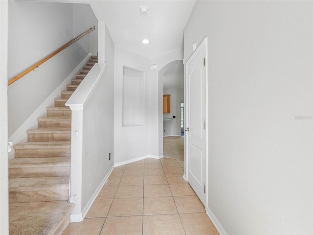 12820 Belvedere Song Way, Riverview, FL 33578 - hallway with arched walkways, light tile patterned floors, stairway, and recessed lighting