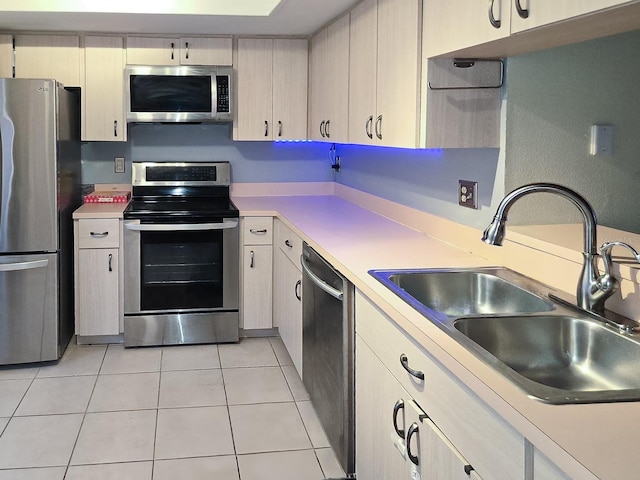 kitchen with light tile patterned flooring, appliances with stainless steel finishes, and sink