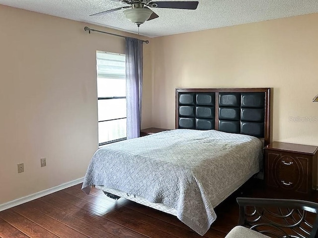 bedroom with a textured ceiling, dark hardwood / wood-style floors, and ceiling fan