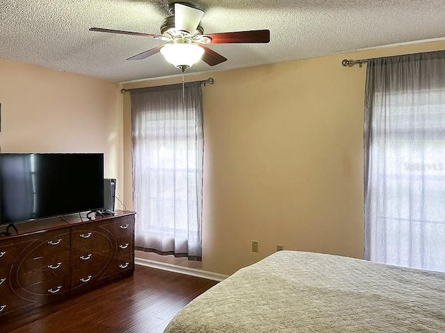 bedroom featuring ceiling fan, a textured ceiling, and dark hardwood / wood-style floors