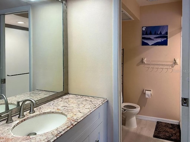 bathroom featuring hardwood / wood-style floors, vanity, and toilet