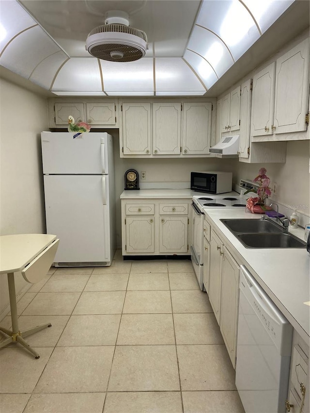 kitchen with light tile patterned floors, white appliances, under cabinet range hood, light countertops, and a sink
