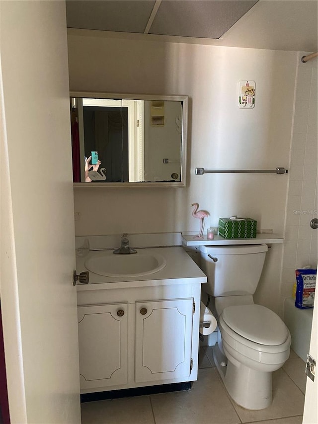 bathroom featuring toilet, tile patterned flooring, and vanity