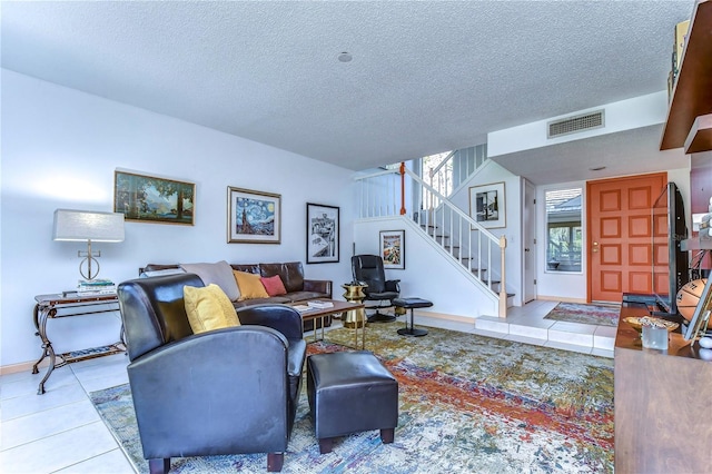 living room with a textured ceiling and light tile patterned floors