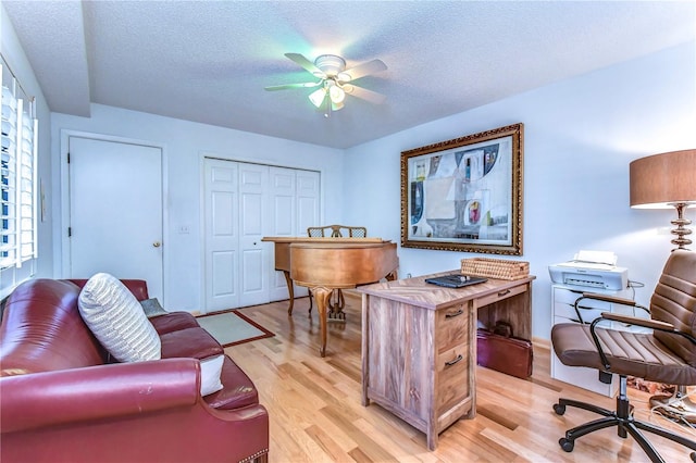 office space featuring ceiling fan, a textured ceiling, and light wood-type flooring