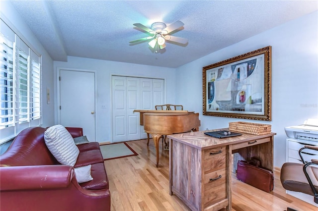 office space with light hardwood / wood-style flooring, a textured ceiling, and ceiling fan