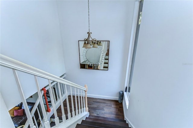 staircase with an inviting chandelier and hardwood / wood-style floors