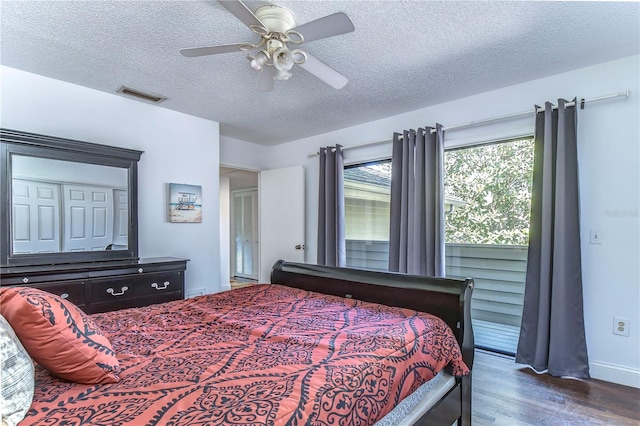 bedroom with ceiling fan, dark hardwood / wood-style floors, and a textured ceiling