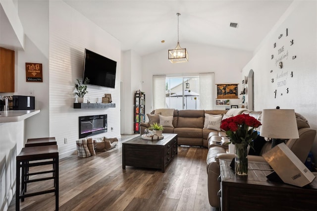 living room with an inviting chandelier, a fireplace, dark hardwood / wood-style floors, and high vaulted ceiling