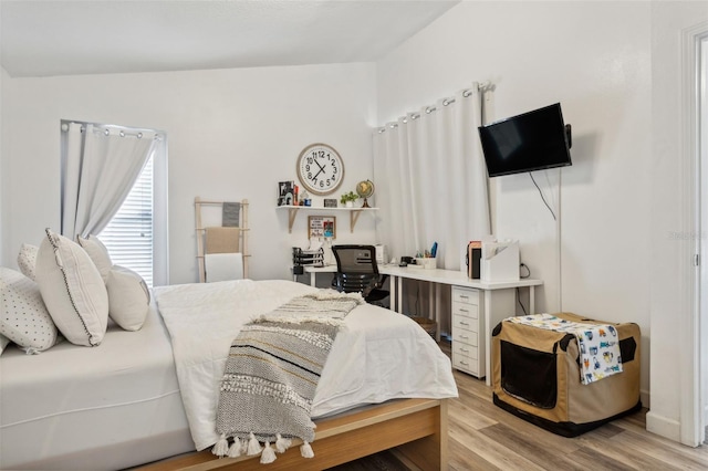 bedroom with light hardwood / wood-style flooring and vaulted ceiling