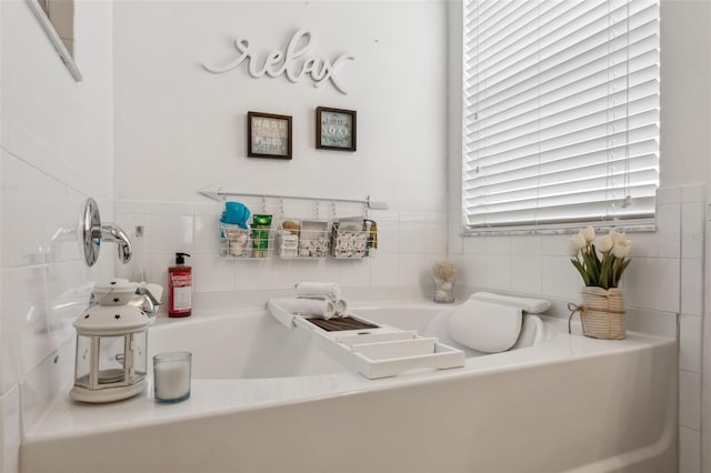 bathroom with tile walls and a bathing tub