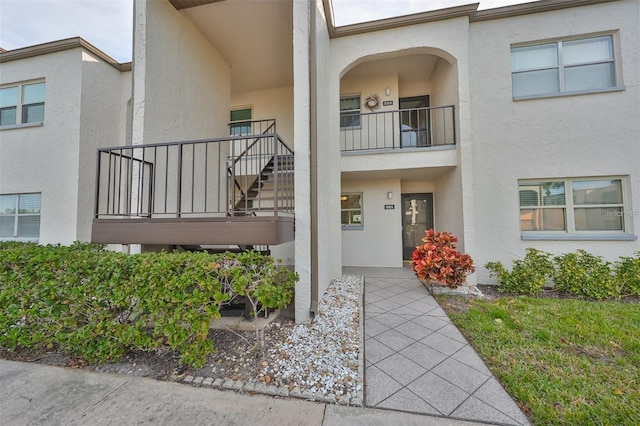 view of exterior entry with a balcony