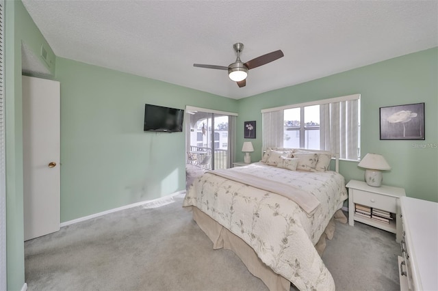 bedroom featuring a textured ceiling, ceiling fan, and light colored carpet