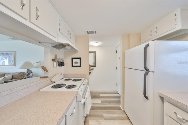 kitchen with light hardwood / wood-style floors, white appliances, and white cabinets