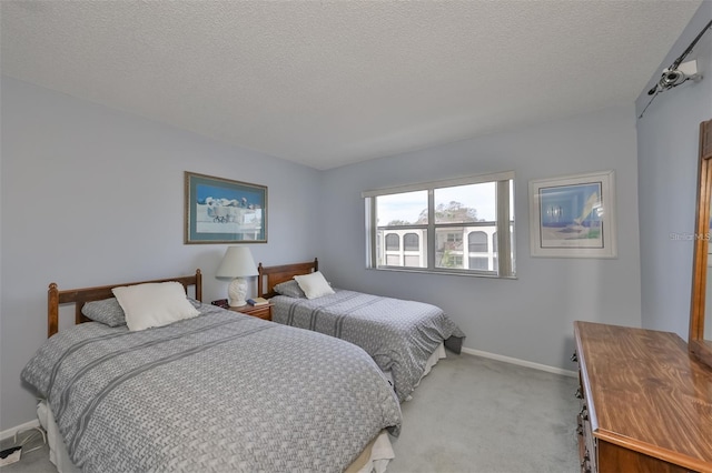 bedroom with light carpet and a textured ceiling