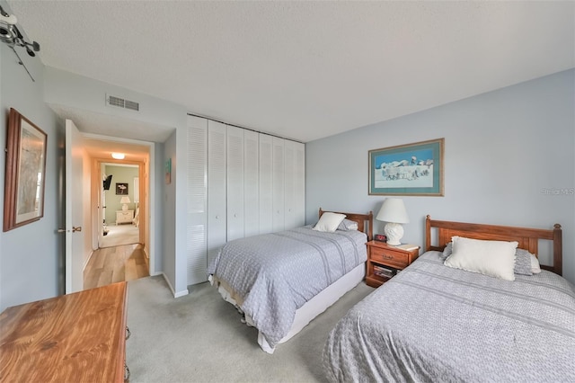 bedroom with light carpet and a closet