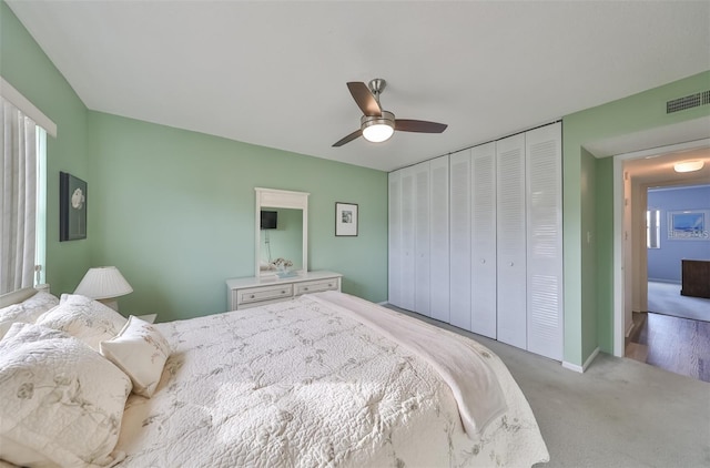 bedroom with light carpet, ceiling fan, and a closet