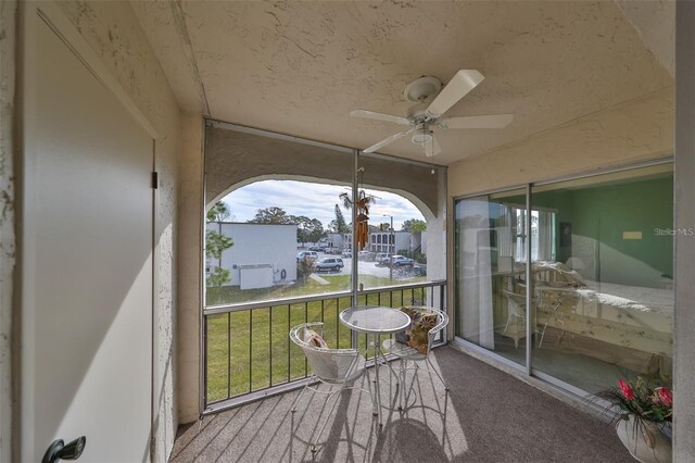 sunroom featuring ceiling fan