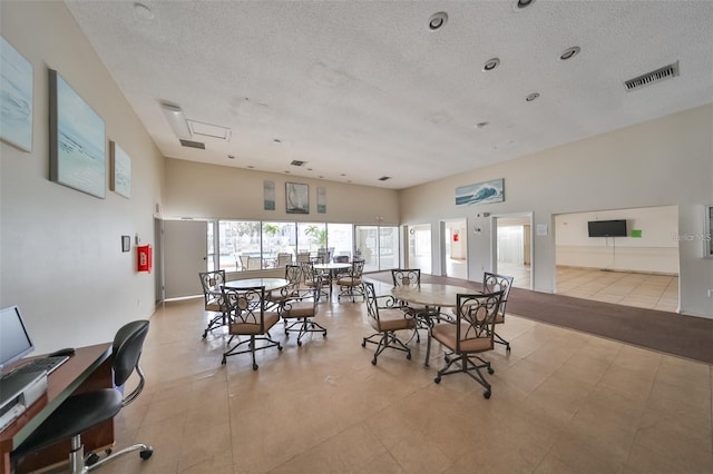 dining room with a textured ceiling and light tile patterned floors