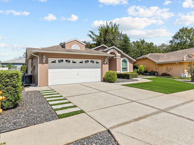 single story home with a garage and a front lawn