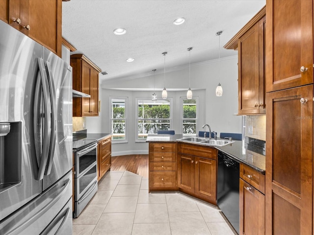 kitchen with light tile patterned flooring, sink, vaulted ceiling, stainless steel appliances, and decorative light fixtures