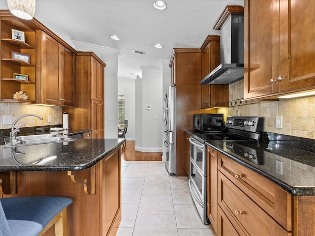 kitchen featuring appliances with stainless steel finishes, dark stone countertops, crown molding, sink, and wall chimney range hood