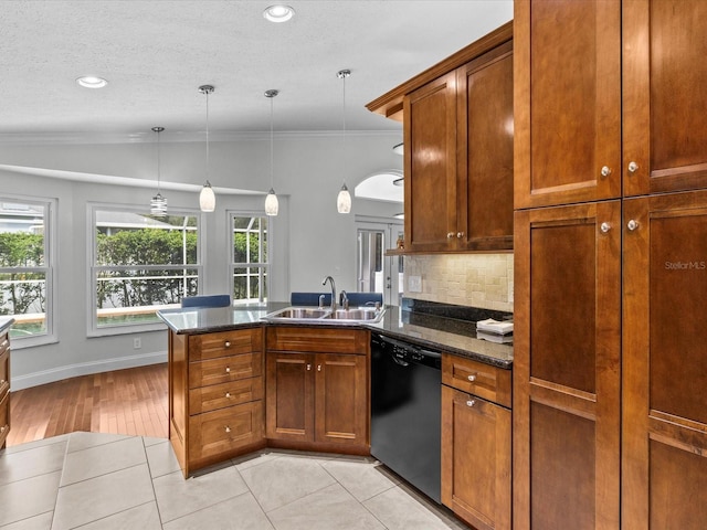 kitchen featuring vaulted ceiling, black dishwasher, light wood-type flooring, decorative light fixtures, and sink