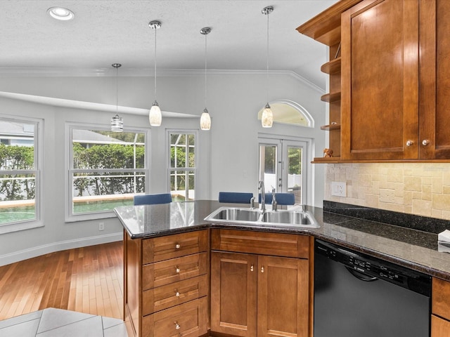 kitchen with wood-type flooring, lofted ceiling, a wealth of natural light, stainless steel dishwasher, and sink