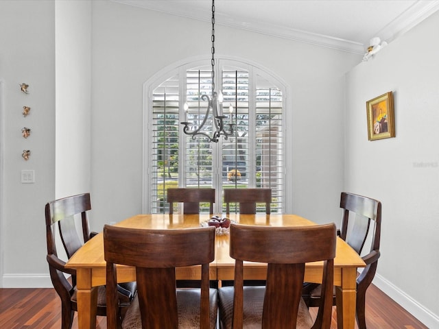 dining space with dark hardwood / wood-style floors, ornamental molding, and a chandelier