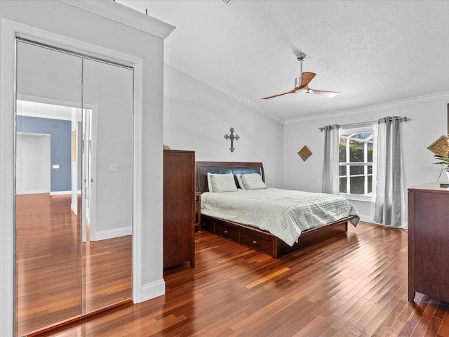 bedroom featuring ceiling fan, a textured ceiling, hardwood / wood-style flooring, a closet, and crown molding