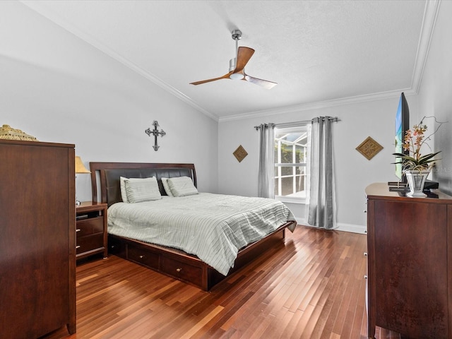 bedroom with ceiling fan, a textured ceiling, crown molding, and dark hardwood / wood-style flooring