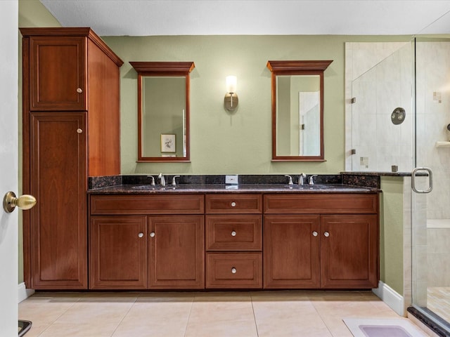 bathroom with a shower with door, vanity, and tile patterned floors