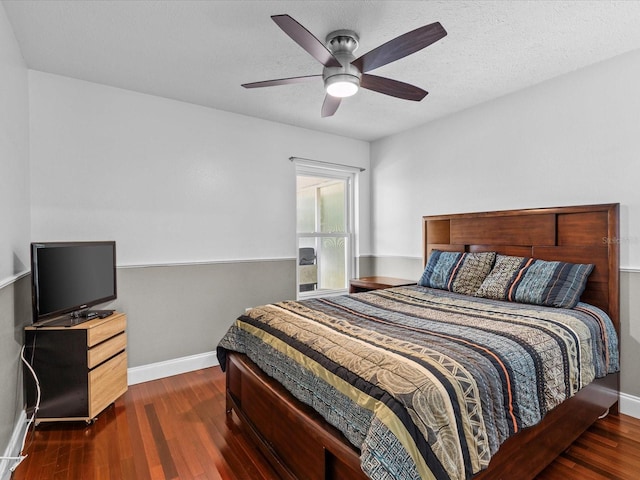 bedroom with a textured ceiling, dark hardwood / wood-style floors, and ceiling fan