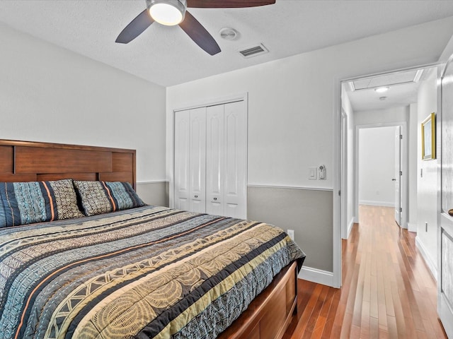 bedroom featuring ceiling fan, a textured ceiling, a closet, and hardwood / wood-style floors