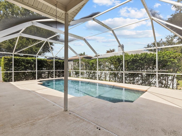 view of swimming pool with glass enclosure and a patio area