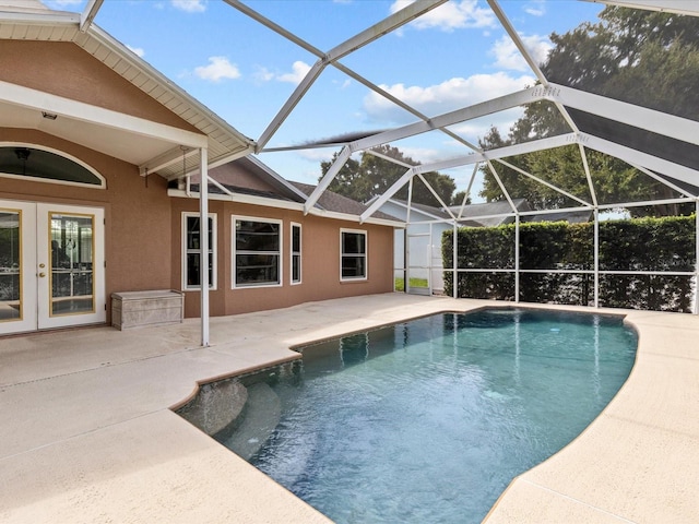 view of swimming pool with glass enclosure and a patio area