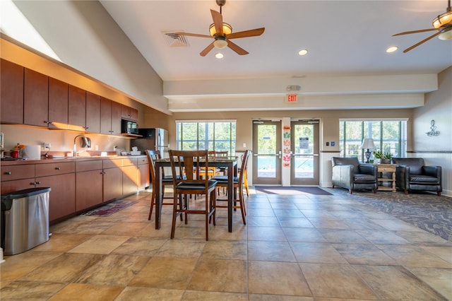 dining area featuring french doors, ceiling fan, and sink