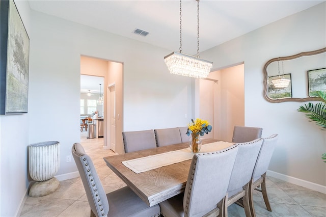 dining room with light tile patterned flooring and a notable chandelier