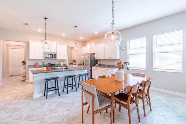 dining area with light tile patterned flooring and sink