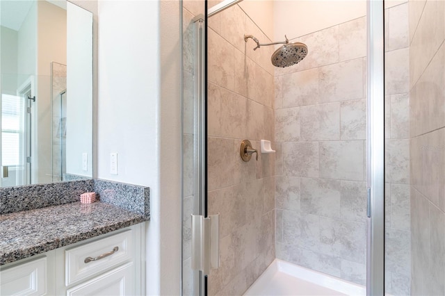 bathroom featuring walk in shower and vanity