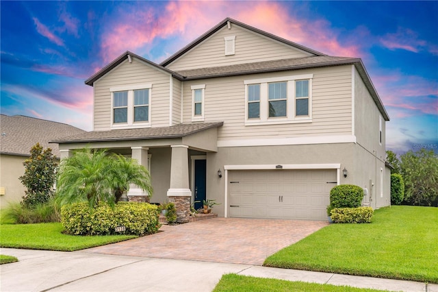 view of front of property featuring a garage and a lawn