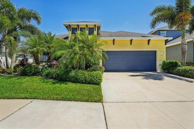 view of front of home with a front yard and a garage