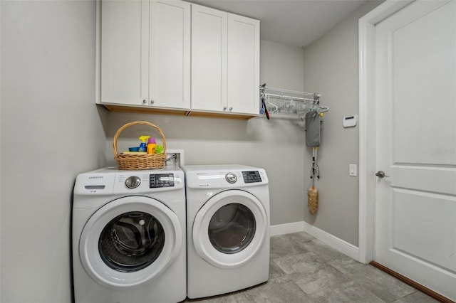 washroom featuring cabinets and washing machine and clothes dryer