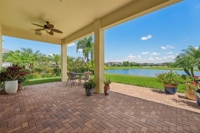 view of patio with ceiling fan and a water view