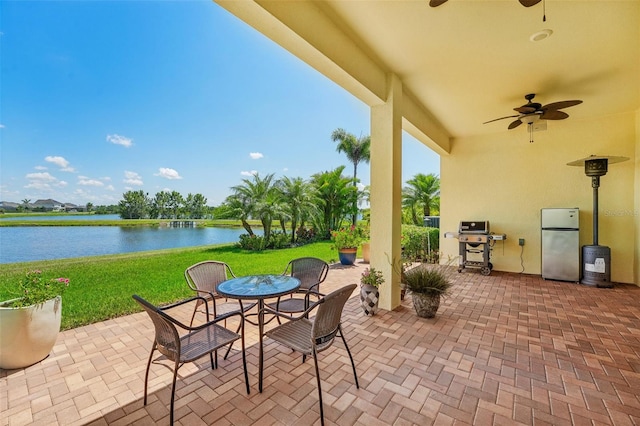 view of patio / terrace featuring ceiling fan, area for grilling, and a water view