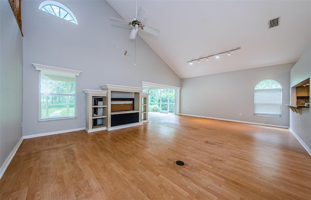 unfurnished living room with light wood-type flooring, high vaulted ceiling, and ceiling fan