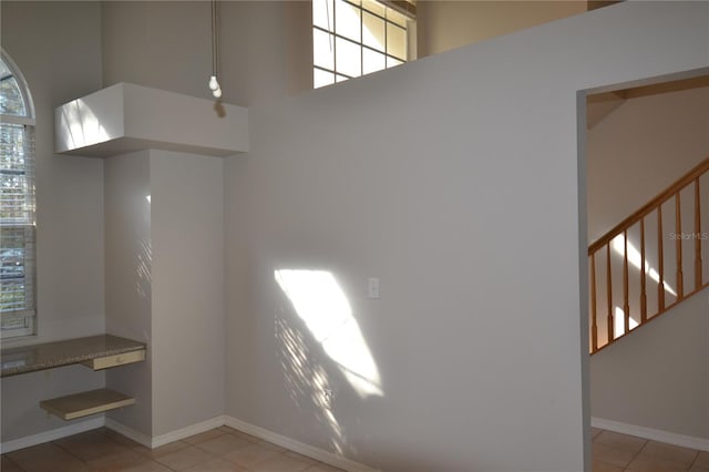 interior space featuring light tile patterned floors and a high ceiling