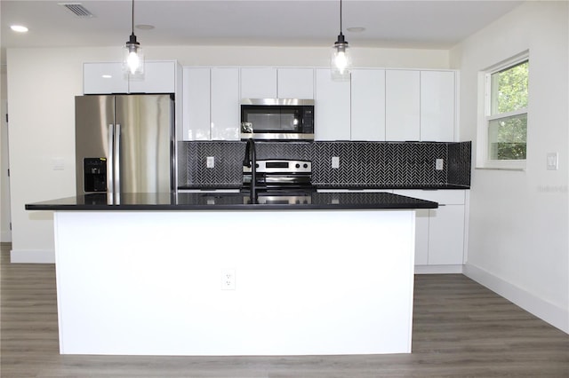 kitchen featuring an island with sink, appliances with stainless steel finishes, and white cabinetry